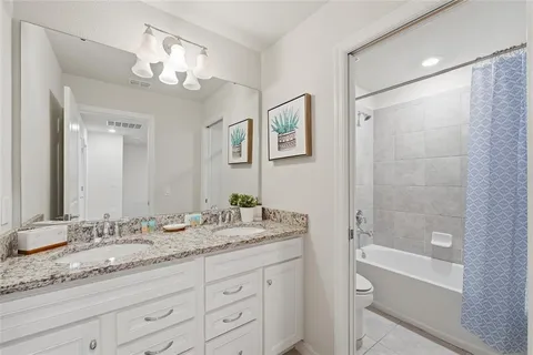 a bathroom with a granite countertop sink a mirror a shower and a bathtub