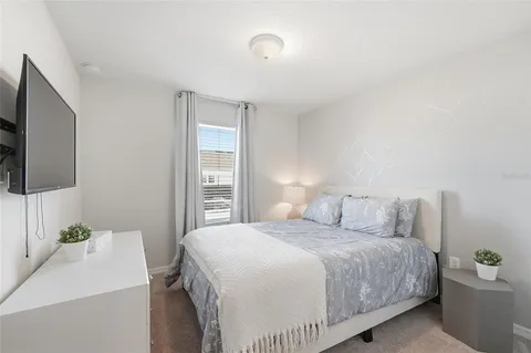 a bedroom with a bed and a flat screen tv