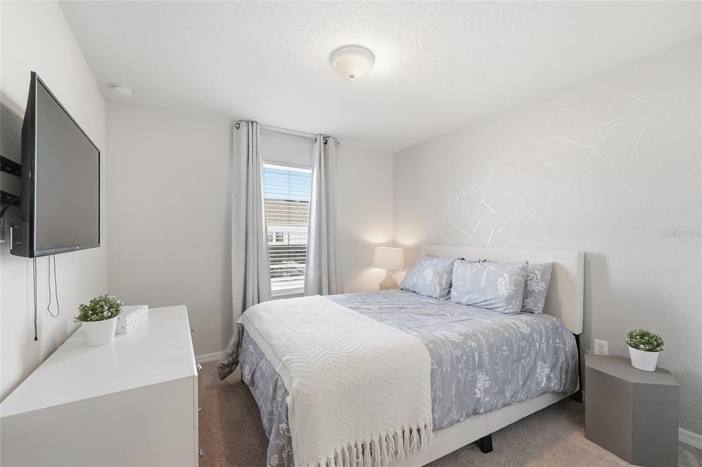 236 Jetty Way Davenport, FL 33897 - Photo 18 of 25 a bedroom with a bed and a flat screen tv