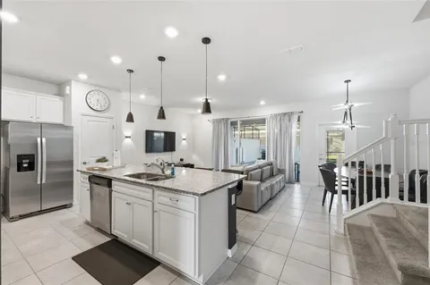 a kitchen with stainless steel appliances granite countertop a sink a stove and a refrigerator