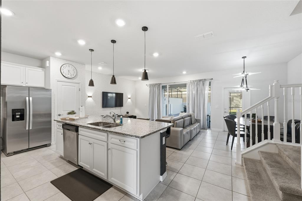236 Jetty Way Davenport, FL 33897 - Photo 3 of 25 a kitchen with stainless steel appliances granite countertop a sink a stove and a refrigerator