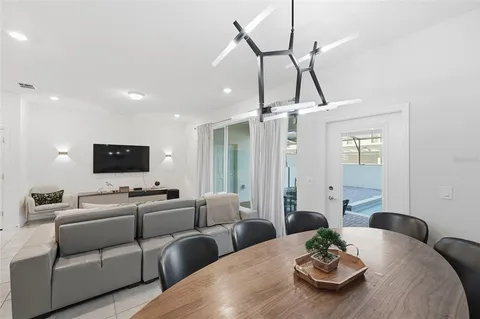 a living room with furniture kitchen view and a wooden floor