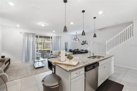 a open kitchen with a sink a stove a dining table and chairs