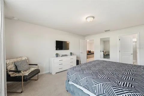 a bedroom with a bed and flat screen tv