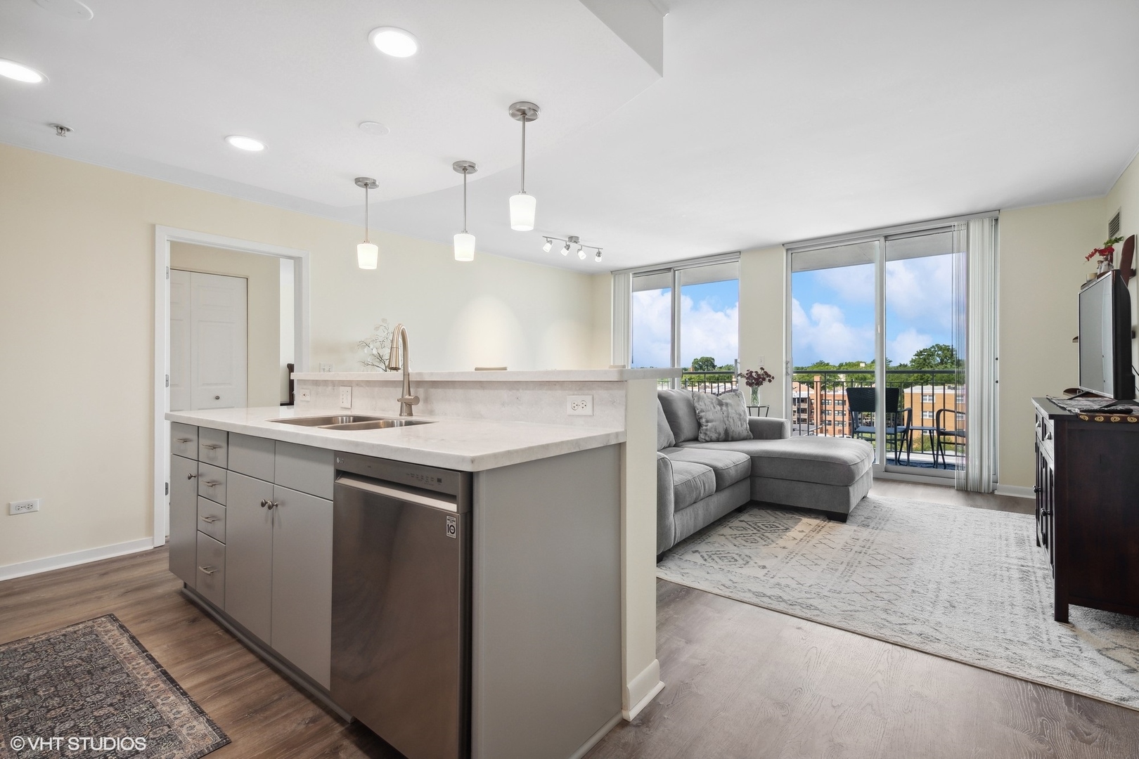 1640 Maple Avenue, Unit 704 Evanston, IL 60201 - Photo 4 of 15 a kitchen with kitchen island a large counter top space a sink stainless steel appliances and cabinets
