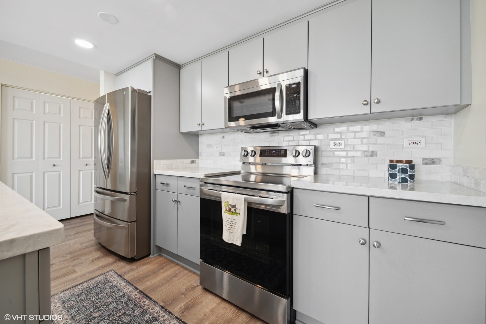 1640 Maple Avenue, Unit 704 Evanston, IL 60201 - Photo 7 of 15 a kitchen with stainless steel appliances granite countertop a refrigerator stove a sink and dishwasher with wooden floor