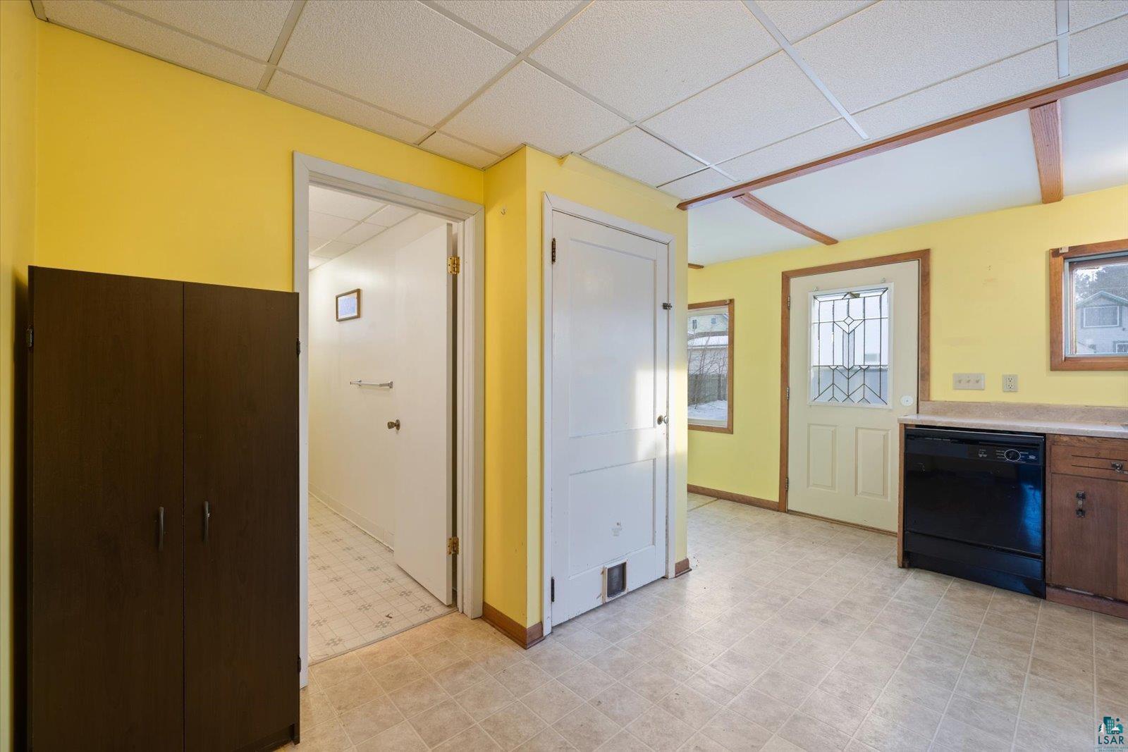 616 Summit Street Eveleth, MN 55734 - Photo 11 of 42 Kitchen featuring black dishwasher, light floors, a drop ceiling, and light countertops
