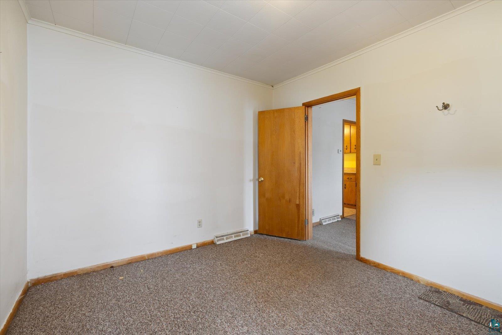 616 Summit Street Eveleth, MN 55734 - Photo 13 of 42 Spare room featuring carpet flooring and crown molding