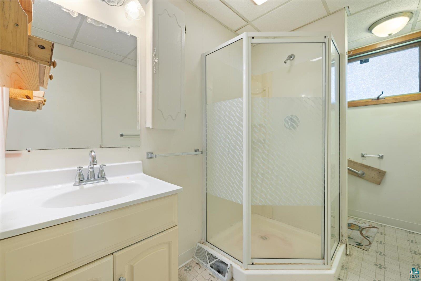 616 Summit Street Eveleth, MN 55734 - Photo 18 of 42 Full bath with vanity, a stall shower, a paneled ceiling, and light floors