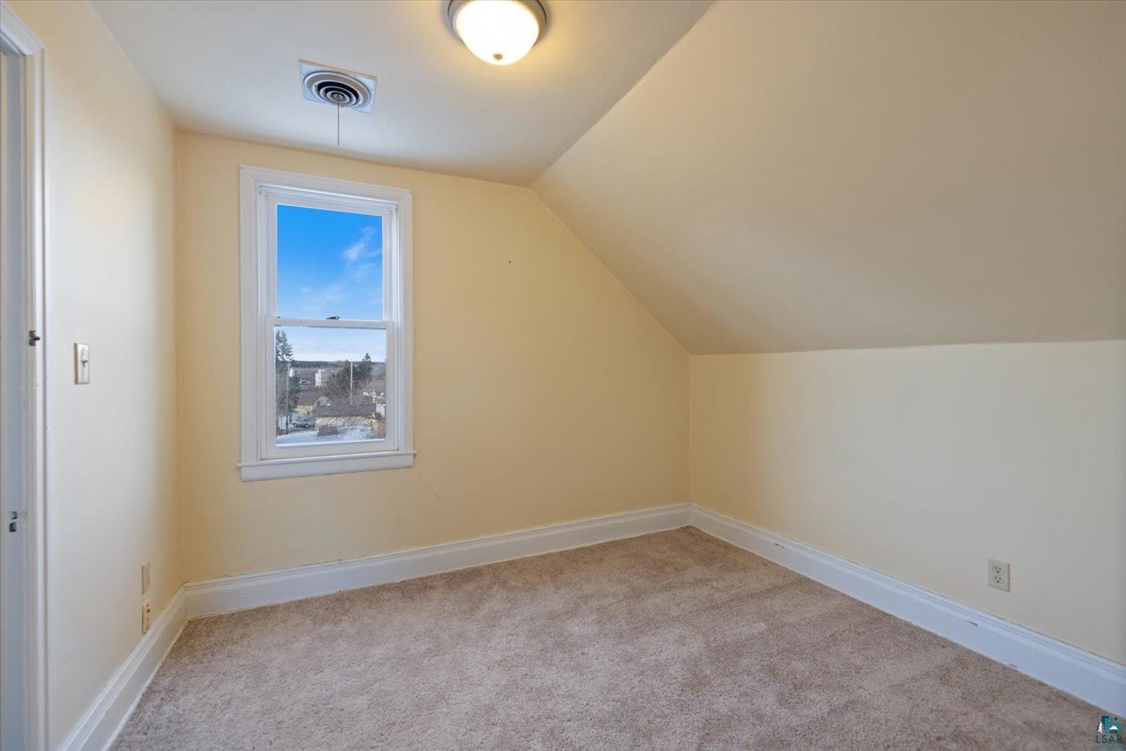 616 Summit Street Eveleth, MN 55734 - Photo 23 of 42 Additional living space with light colored carpet and vaulted ceiling