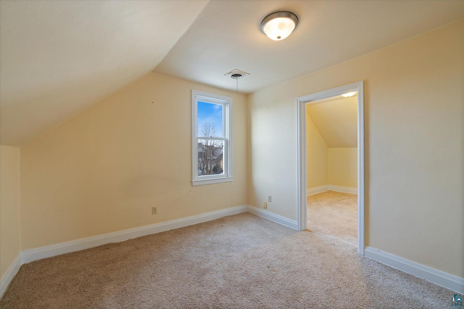 616 Summit Street Eveleth, MN 55734 - Photo 25 of 42 Additional living space featuring vaulted ceiling and light carpet