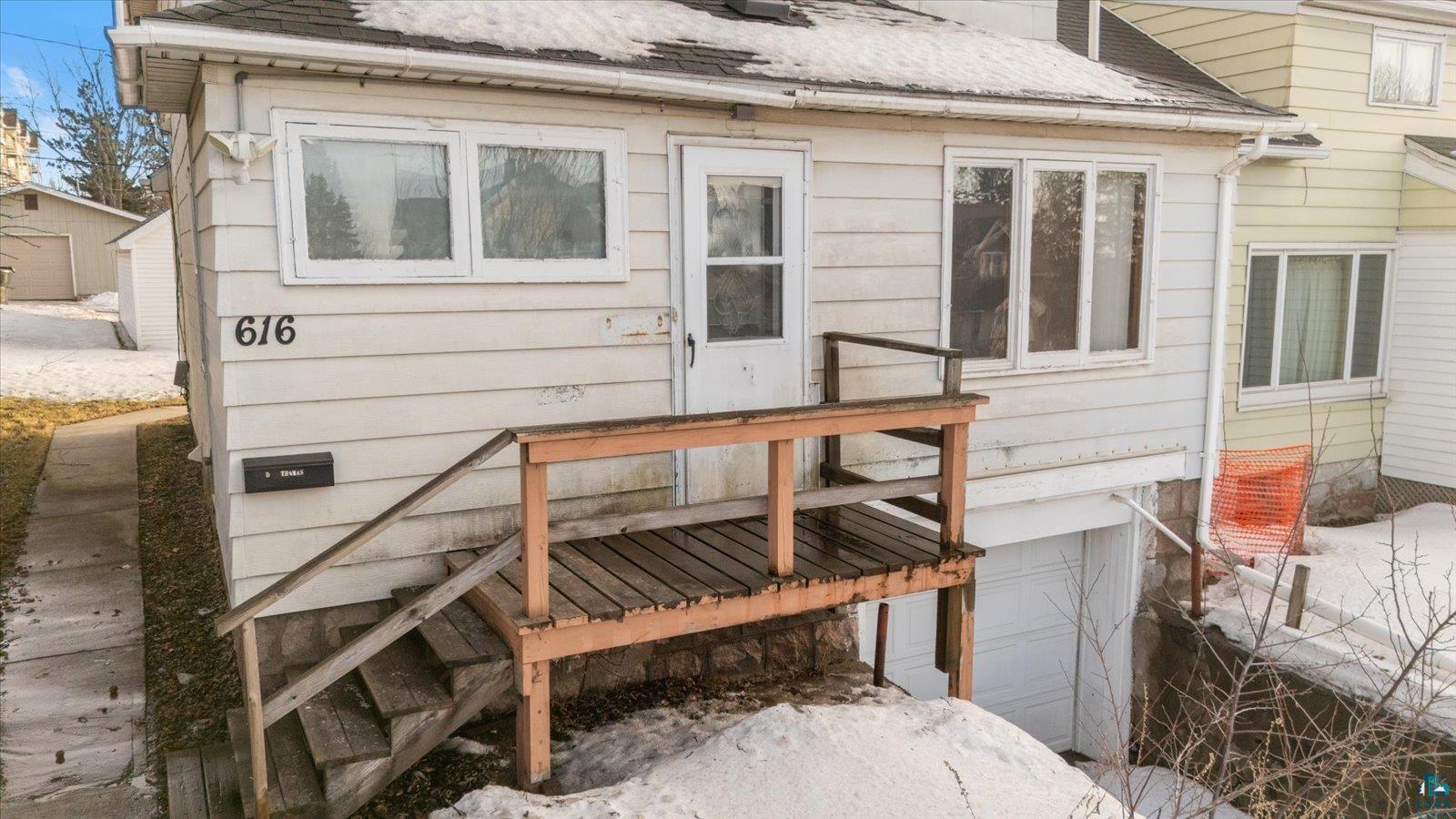 616 Summit Street Eveleth, MN 55734 - Photo 42 of 42 View of exterior entry featuring a deck, an attached garage, and roof with shingles