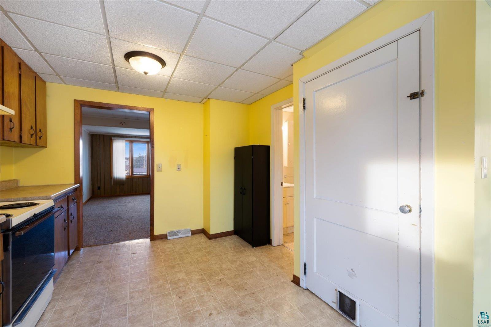 616 Summit Street Eveleth, MN 55734 - Photo 9 of 42 Kitchen with electric range, a paneled ceiling, wood finish cabinets, and light countertops