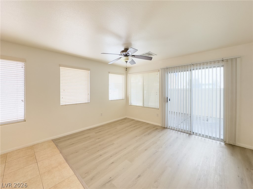 9456 Grandview Spring Avenue Las Vegas, NV 89166 - Photo 8 of 49 A well-lit interior space features sleek wood flooring and a convenient sliding glass door for outdoor access.