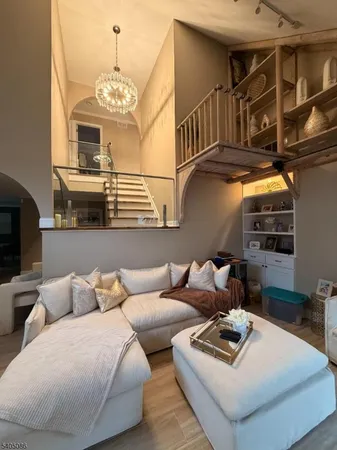 a living room with furniture a fireplace and a chandelier