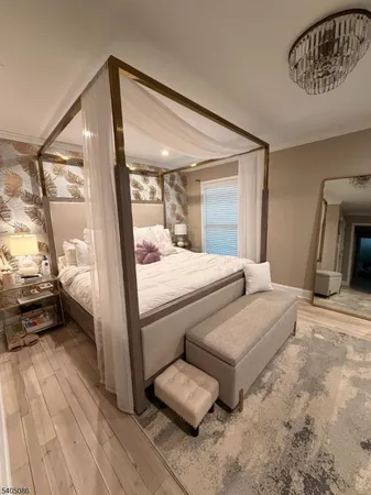 a bedroom with a bed and a large mirror with wooden floor