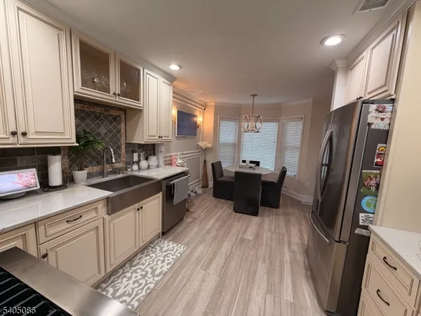 a kitchen with stainless steel appliances a refrigerator sink and cabinets