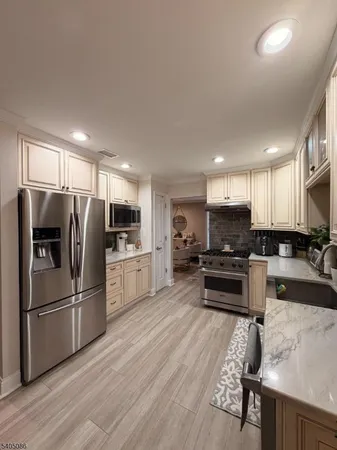 a kitchen with stainless steel appliances a refrigerator and a stove top oven