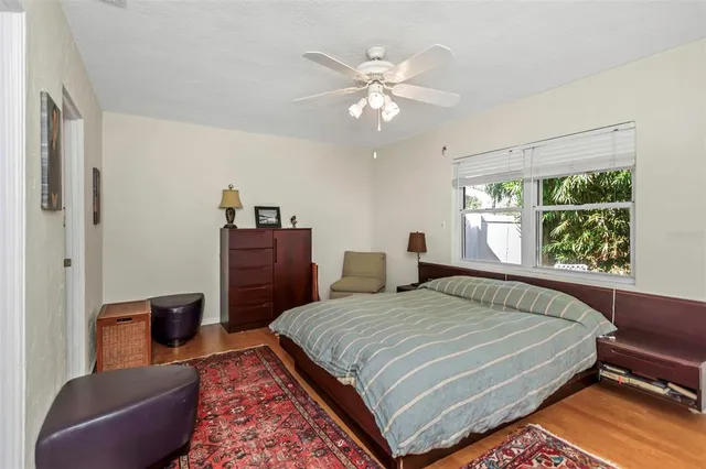 a bedroom with a bed and a flat tv screen on the dresser