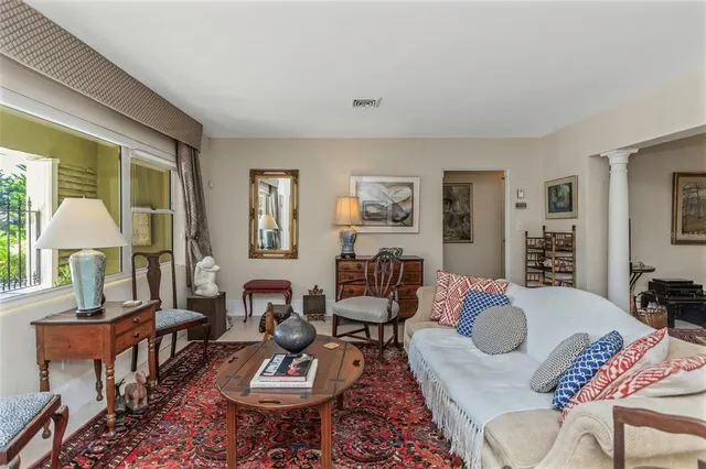 a living room with furniture a chandelier and a rug