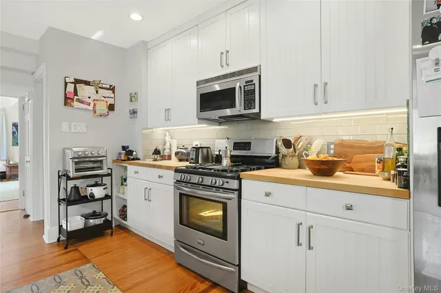 a kitchen with stainless steel appliances a stove a microwave and cabinets