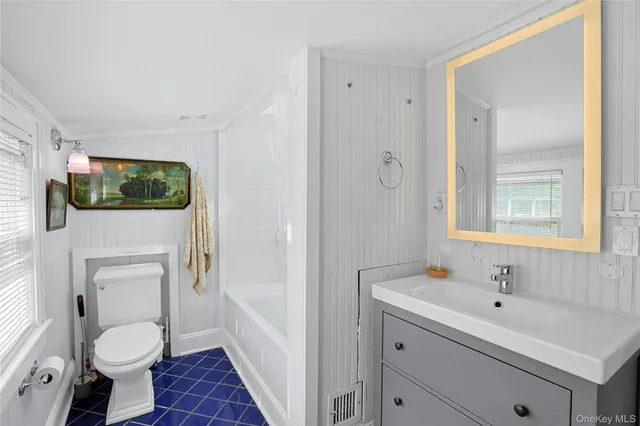 a spacious bathroom with a toilet sink and mirror