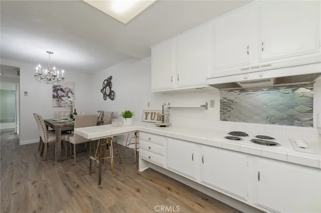 a kitchen with stainless steel appliances granite countertop a sink cabinets and wooden floor