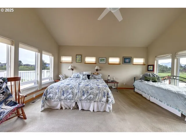 a spacious bedroom with a bed a couch and large window