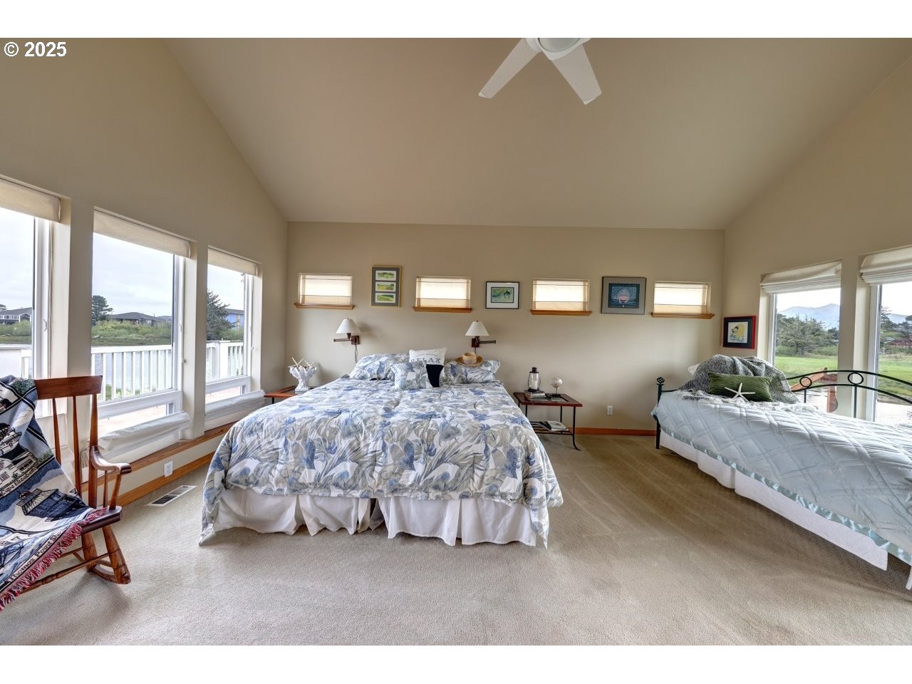 500 Farrell Court Seaside, OR 97138 - Photo 23 of 39 a spacious bedroom with a bed a couch and large window