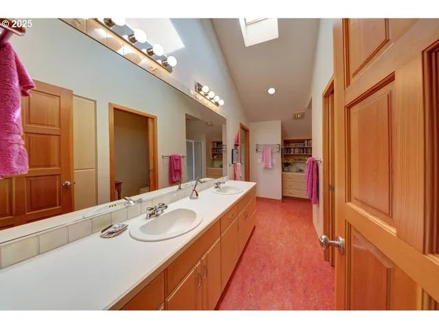 a bathroom with a sink double vanity granite tub shower and a mirror