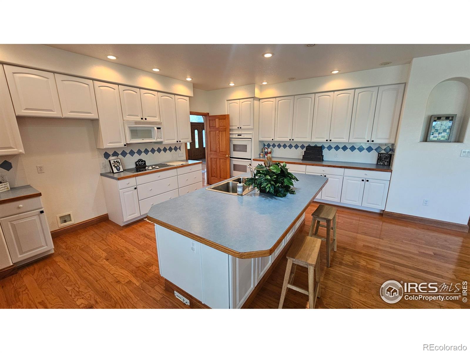 17606 County Rd Q.8 Fort Morgan, CO 80701 - Photo 17 of 37 a kitchen with stainless steel appliances kitchen island granite countertop a sink a stove and a refrigerator