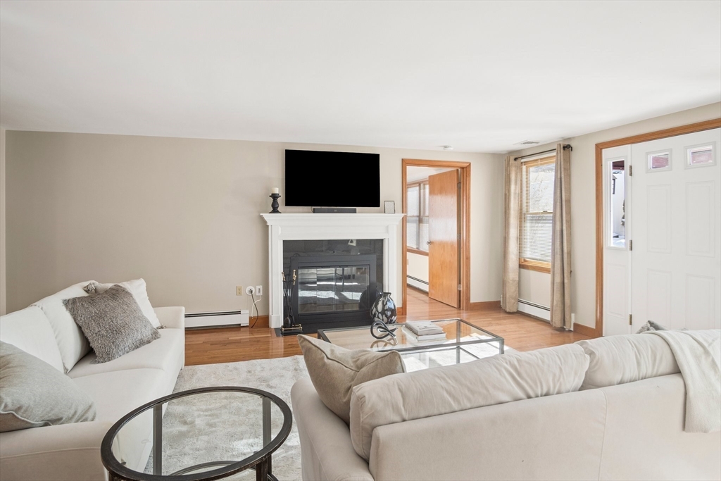 8 Grace Road Woburn, MA 01801 - Photo 4 of 37 a living room with furniture a flat screen tv and a fireplace