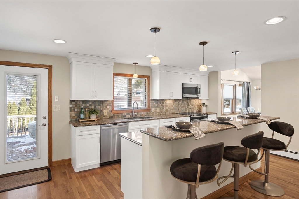 8 Grace Road Woburn, MA 01801 - Photo 9 of 37 a kitchen with a dining table and chairs