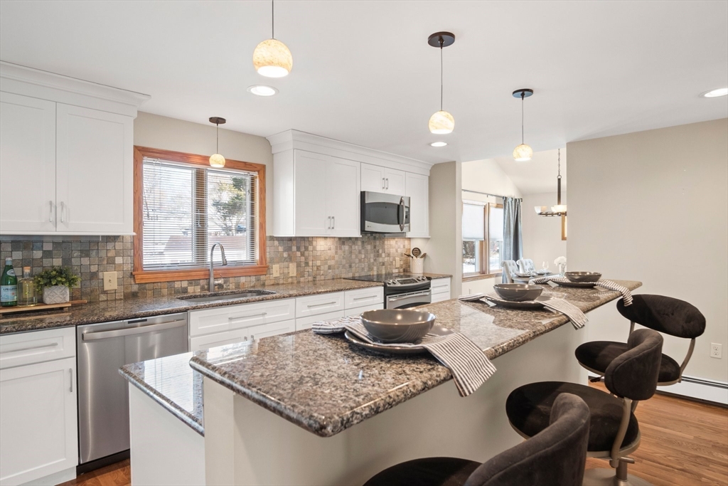 8 Grace Road Woburn, MA 01801 - Photo 10 of 37 a kitchen with a table chairs stove and cabinets
