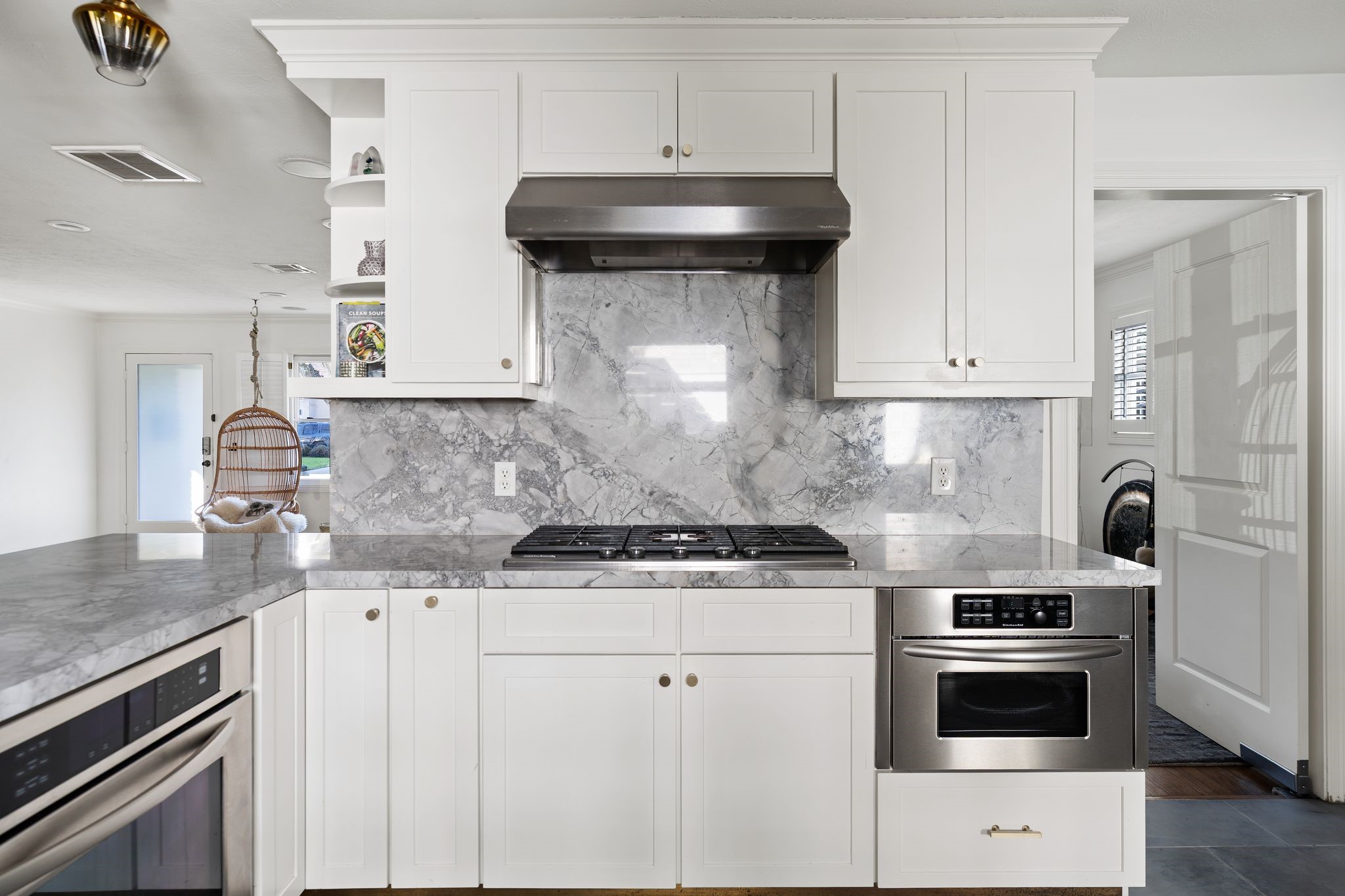 3914 Colquitt Street Houston, TX 77027 - Photo 10 of 36 The cooking area is anchored by a stainless steel vent hood, a KitchenAid five burner gas cooktop, and a pullout spice rack perfect for everyday cooking. The door to the right leads directly into the living room keeping the main living spaces easily connected. There is also a pantry cabinet with pull out drawers.