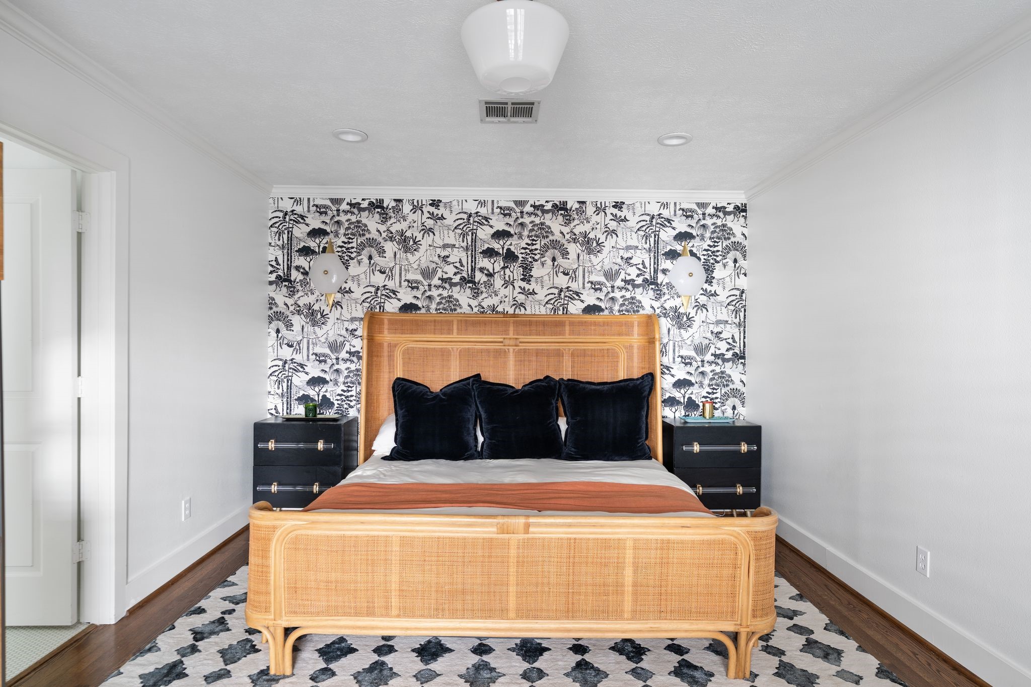 3914 Colquitt Street Houston, TX 77027 - Photo 11 of 36 The primary bedroom is tucked away at the back of the home for added privacy it features a statement wallpaper accent wall with stylish wall sconces plus double doors with plantation shutters that open to the patio.