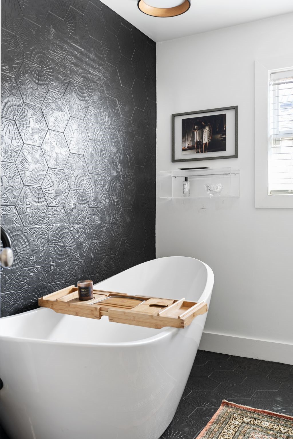3914 Colquitt Street Houston, TX 77027 - Photo 18 of 36 A sleek soaking tub creates a true spa-like moment in this guest bath. Set against a dramatic feature wall, it's a perfect spot to unwind after a long day and enjoy a relaxing bath.