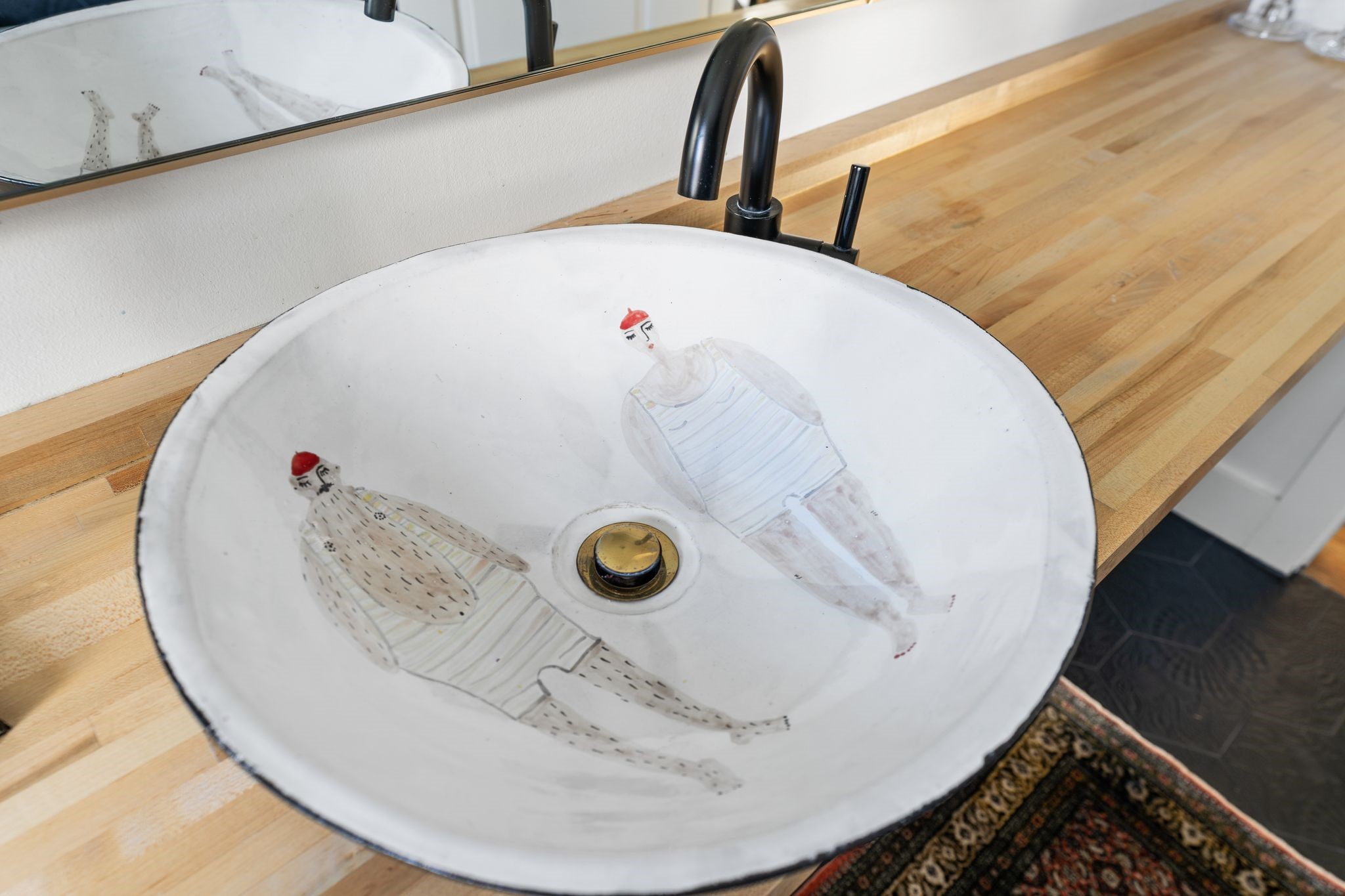 3914 Colquitt Street Houston, TX 77027 - Photo 19 of 36 A unique vessel sink imported from Portugal adds character and craftsmanship to the vanity area. Paired with the wood countertop and modern hardware, it brings in one of a kind finish to this guest bathroom.