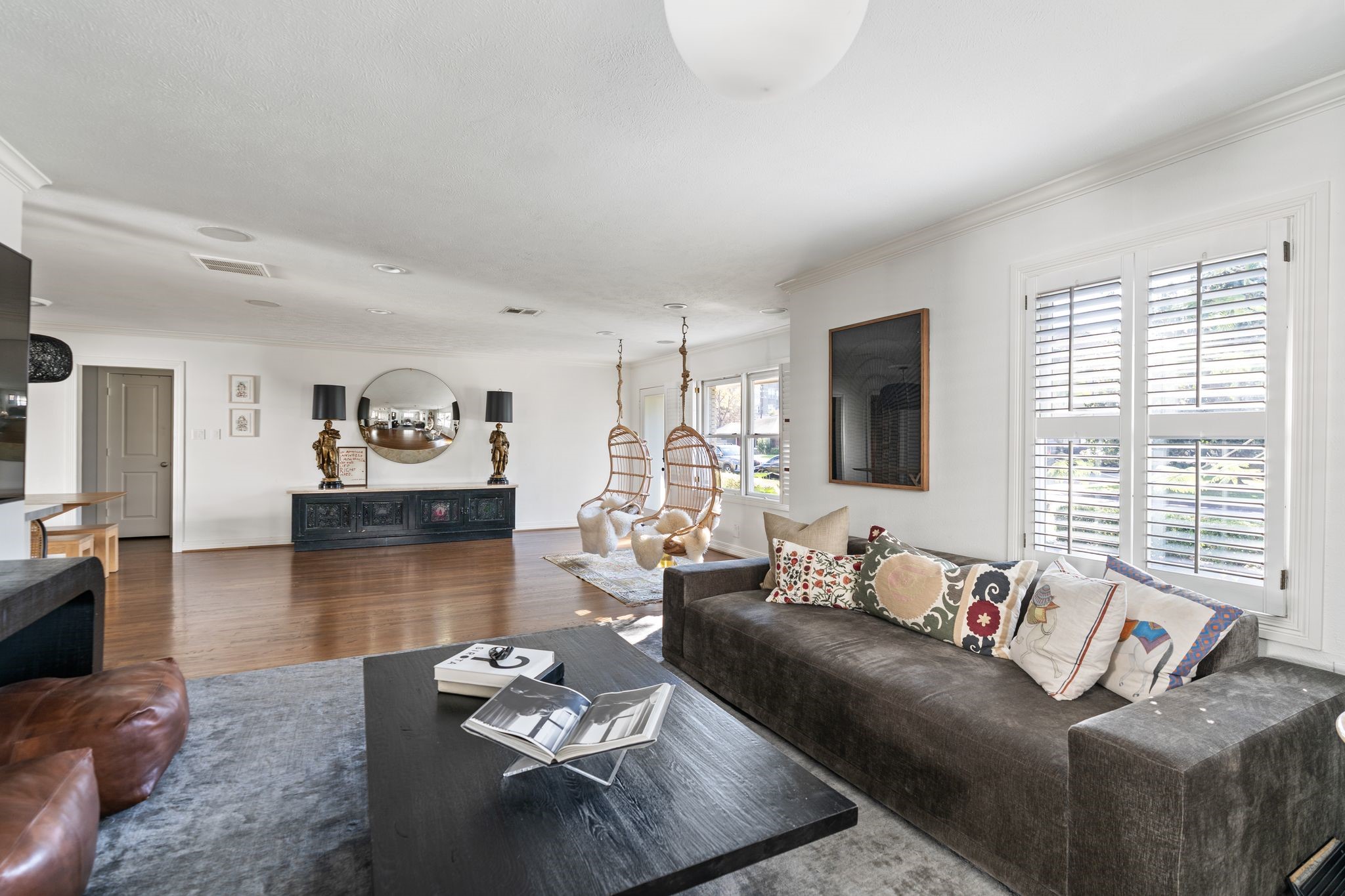 3914 Colquitt Street Houston, TX 77027 - Photo 5 of 36 This additional view highlights the living room's spacious layout and open flow to the front sitting area. Large windows with plantation shutters bring in great natural light making the space feel bright.