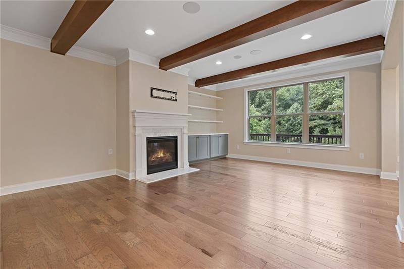 4105 Bellehurst Lane Cumming, GA 30040 - Photo 13 of 48 an empty room with wooden floor fireplace and windows
