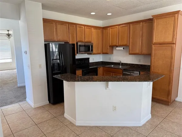 a kitchen with stainless steel appliances granite countertop a refrigerator a stove top oven a sink and dishwasher