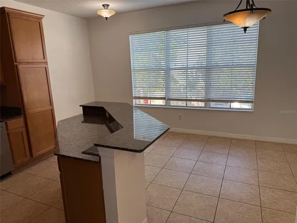 a kitchen with a granite countertop sink and cabinets