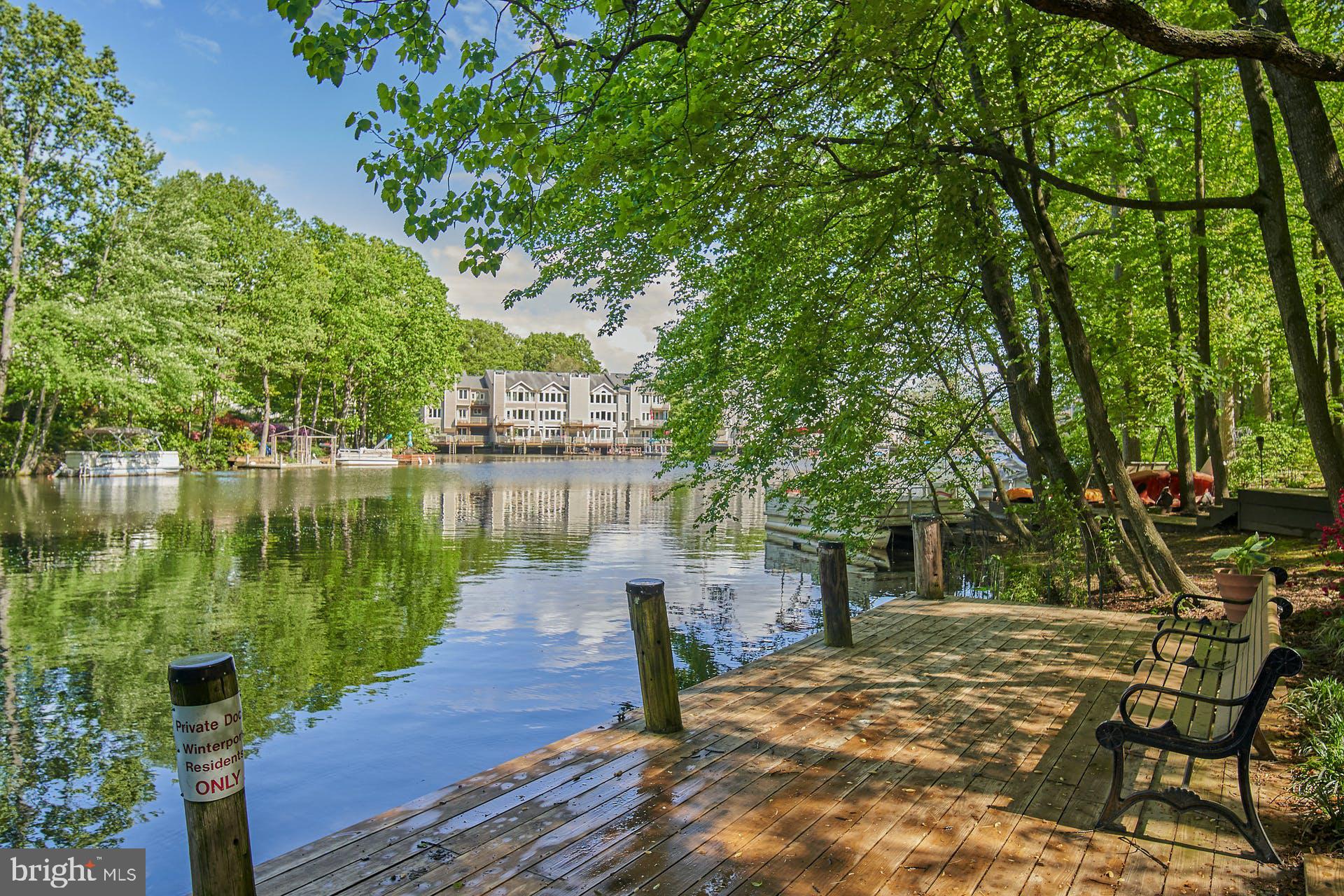 1944 Winterport Cluster Reston, VA 20191 - Photo 26 of 35 a view of a lake with a bench next to a yard