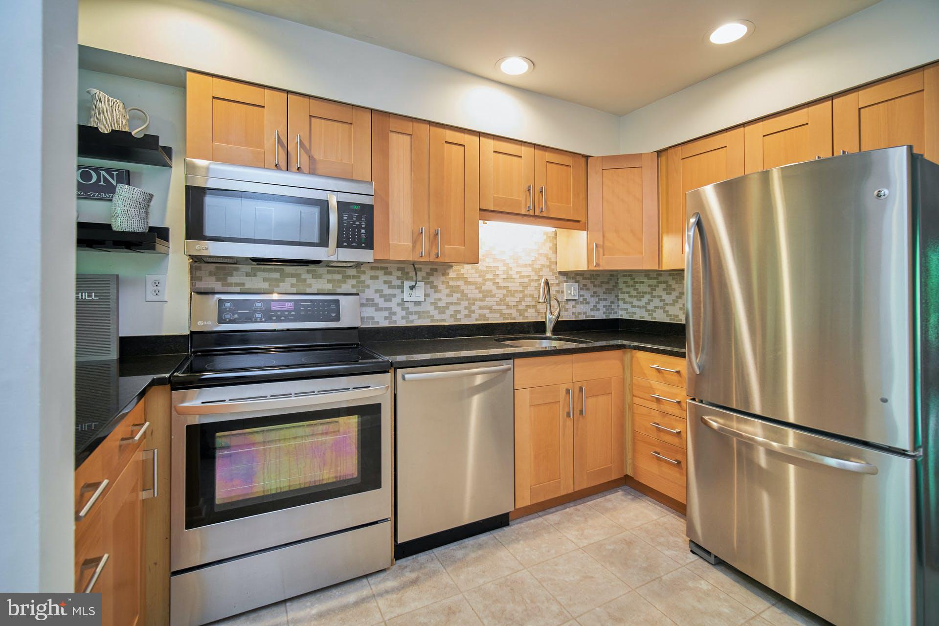 1944 Winterport Cluster Reston, VA 20191 - Photo 6 of 35 a kitchen with stainless steel appliances granite countertop a refrigerator sink and microwave
