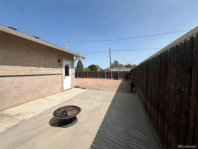 a view of a backyard with wooden fence