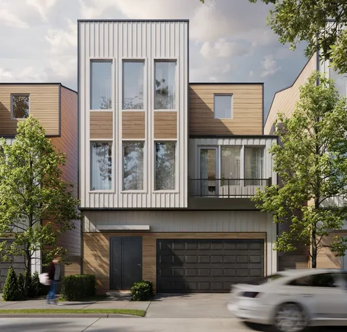 a front view of a building with a garden and parking