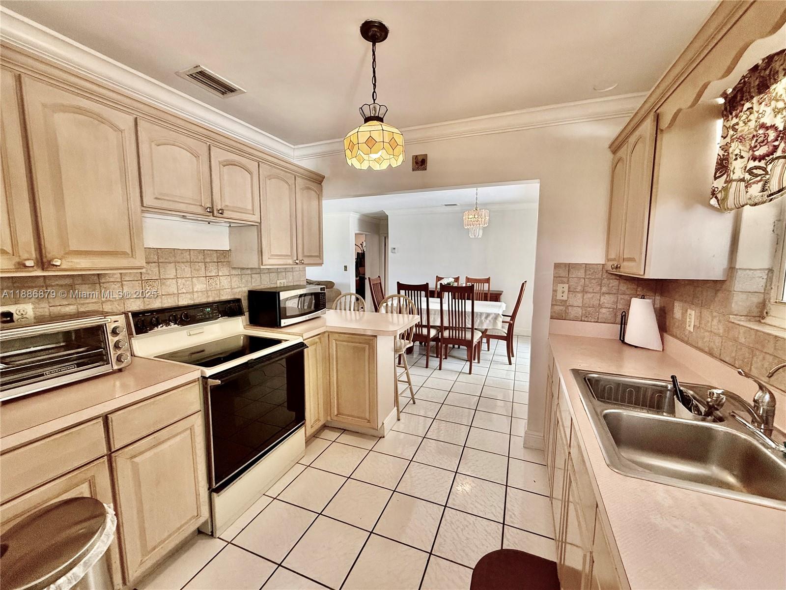 3310 Southwest 94th Place Miami, FL 33165 - Photo 11 of 24 a kitchen with a sink stove and cabinets