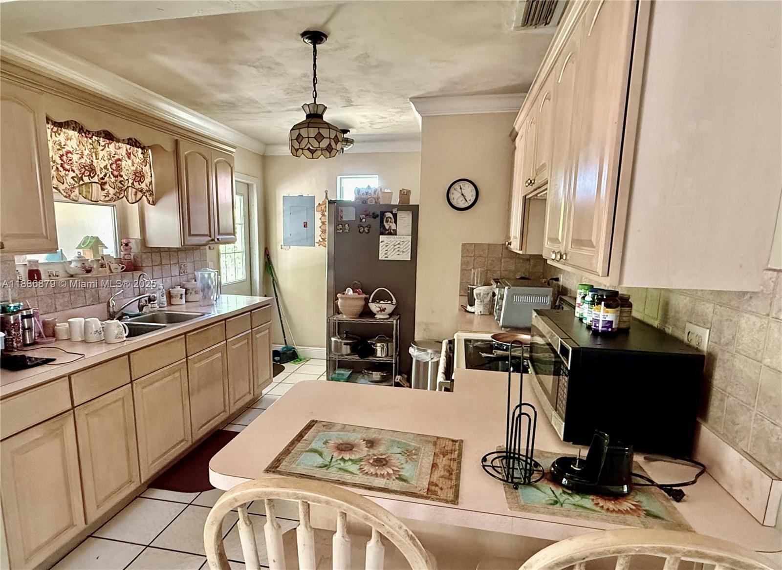 3310 Southwest 94th Place Miami, FL 33165 - Photo 12 of 24 a living room with furniture a chandelier and a flat screen tv