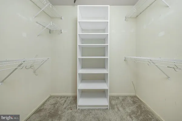 a view of walk in closet with empty racks