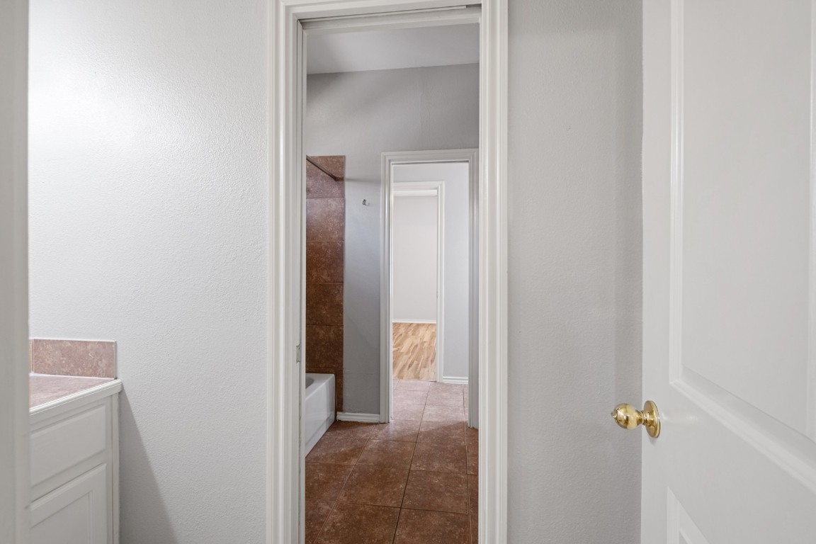 2906 Pearl Street, Unit C Austin, TX 78705 - Photo 16 of 25 Bathroom featuring vanity, bathtub / shower combination, a textured wall, and dark tile patterned floors